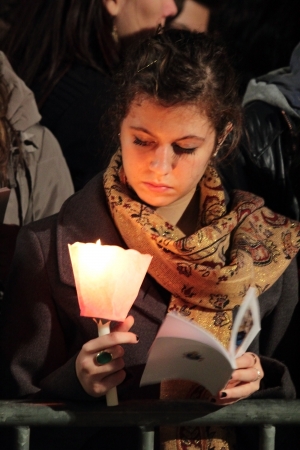 29th March 2013, Colosseum Square, Rome: A girl is reading the booklet of prayers, during for the Stations of the Cross chaired by the Pope Francis I around the coliseum on Good Friday.のeditorial素材