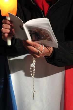 29th March 2013, Colosseum Square, Rome: A pilgrim is reading the booklet of prayers with a rosary in his hands, during the Stations of the Cross chaired by the Pope Francis I around the coliseum on Good Friday.のeditorial素材