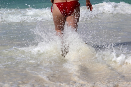 Young woman running in the tropical seaの写真素材