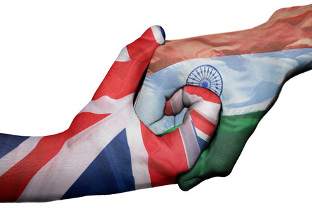 Diplomatic handshake between countries: flags of United Kingdom and India overprinted the two handsの写真素材