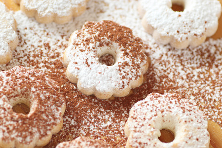 Arrangement of Italian canestrelli cookies on a wooden table, sprinkled with powdered sugar and cocoa. High angle view.の写真素材