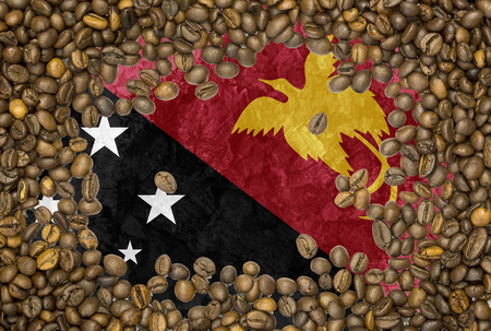 National country flag of Papua New Guinea under a background of roasted brown coffee beansの写真素材