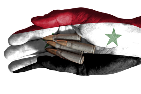 Flag of Iraq overlaid the hand of an adult man holding four bullets. Conceptual image for war, violence, conflicts. Image isolated on white backgroundの写真素材