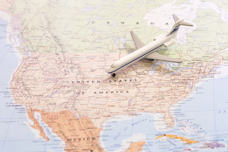 Miniature of a passenger airplane flying on the map of United States of America from north east. Conceptual image for travel and tourismの写真素材