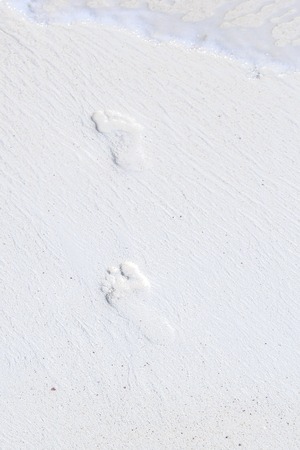 Footprints on the white sand of a tropical beach. Can be used as texture or background.の写真素材