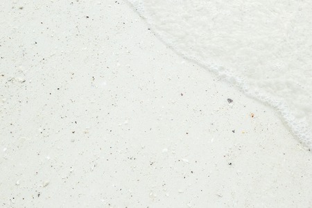 Background of sandy white coastline with water from a tropical beach. Can be used as texture or background.の写真素材