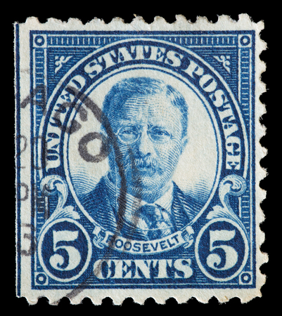 UNITED STATES OF AMERICA - CIRCA 1922: A used postage stamp printed in United States shows a portrait of the President Theodore Roosevelt on blue background, circa 1922のeditorial素材
