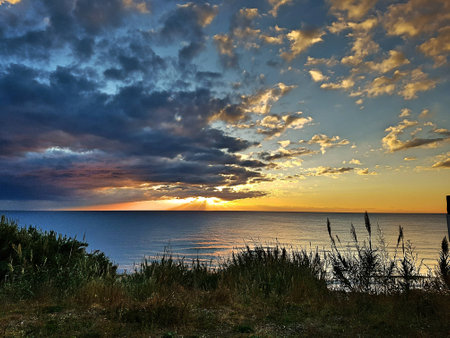 Canneto and grassy field with sunset and clouds.の写真素材