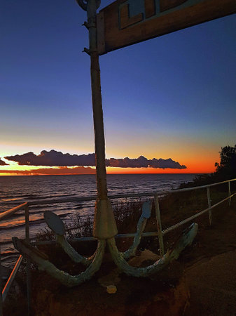 Lonely cloud drawn on the horizon between orange and blue sky.の写真素材