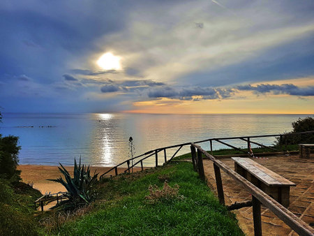 Descent to the sea with calm sea and sun setting.の写真素材
