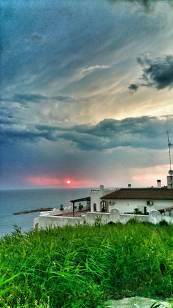 Villa on the sea with turquoise clouds and rose sun.の写真素材