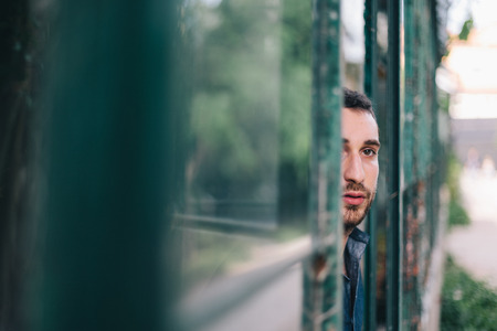 Beautiful Man Watching Through Dirty Windowの写真素材