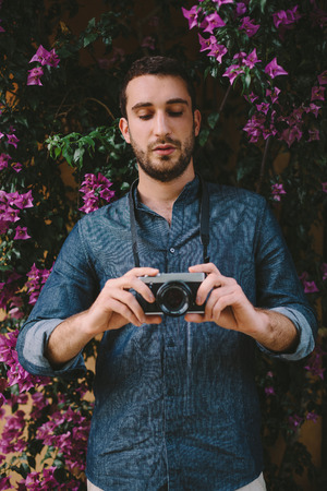 Handsome Man Portrait In Front Of Purple Flowers Backgroundの写真素材