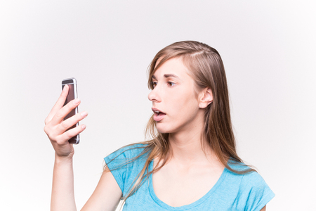 Young Woman Lokking Shocked Her Mobile Phone White Backgroundの写真素材
