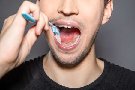 white covered and coated tongue out with tiny bumps is indicator for sickness and infections and reason for bad breath and smell but can be cleaned by tongue coating cleaner by scraping the white foamの写真素材