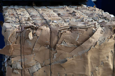pressed brown cardboard boxes is waste and get recycled to new paper and boxed to reuse resources...