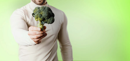 holding broccoli as symbol of healthy lifestyleの写真素材