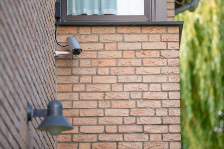 cctv security camera at house wall of private home to monitor property and protect against attack