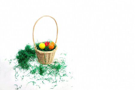happy easter basket with green grass and painted eggs isolated on whiteの写真素材