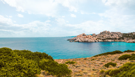 Panoramic view of an island bay out of stone and rocks with boat in it on a cloudy summer dayの写真素材