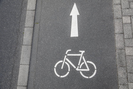 Bike lane ahead sign with arrow painted on asphalt street
