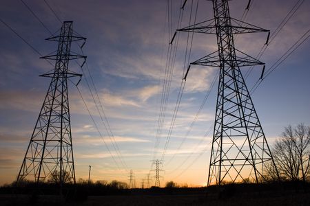 Power lines and towers stretch into the sunset