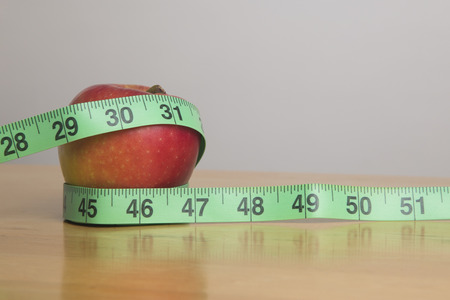Apple and measuring tape, weight conceptの写真素材