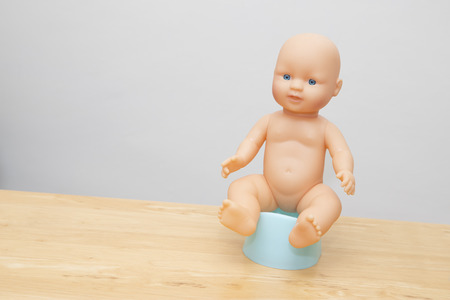 Doll sitting on potty to illistrate potty trainingの写真素材