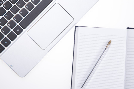 Elevated view of a Laptop and note pad with a penの写真素材