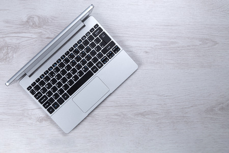Ariel view of open laptop on a white wooden surfaceの写真素材