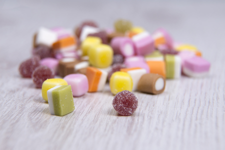Sweets tipped out onto a wooden surface with shallow depth of fieldの写真素材