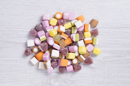 Candy in a small pile on a white woden surfaceの写真素材