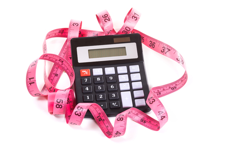 Simple black calculator entangled with red measuring tape marked in inches, isolated on white backgroundの写真素材
