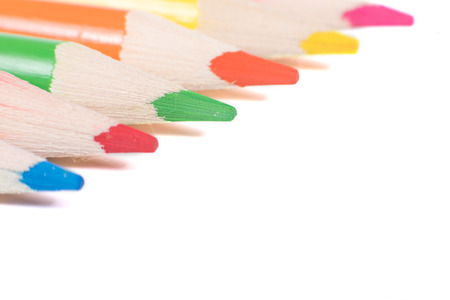 Colored pencils isolated on white background arranged in diagonal, close-up on sharpened tipsの写真素材
