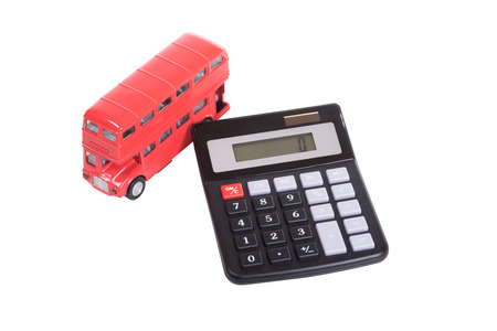 Toy model of an iconic British double-decker red bus and calculator isolated on white in a concept of costs of public transportの写真素材