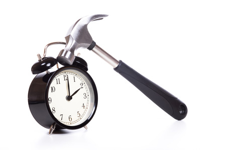 Classic alarm clock hit by hammer tool with black handle isolated on white background with copy spaceの写真素材
