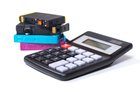 Color printer ink cartridges with simple calculator, close-up detail view from the side, symbolising consumables expenses concept, isolated on white backgroundの写真素材