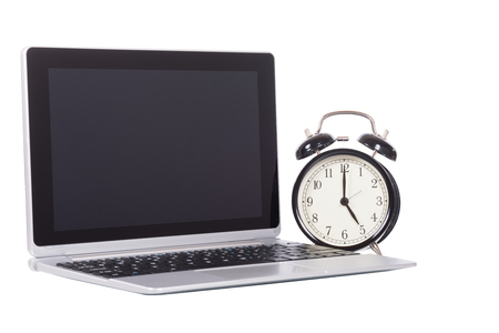 Alarm clock with open blank laptop computer conceptual of business time management and deadlines isolated on whiteの写真素材