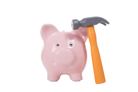 Plastic toy hammer and piggy bank viewed from the front isolated on white backgroundの写真素材