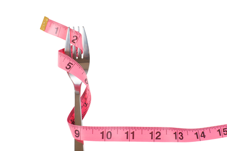 Fork wrapped with a measuring tape through the tines in a concept of loosing weight and dieting isolated on white forming a borderの写真素材