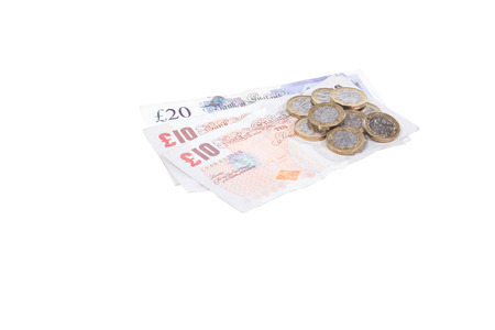 Isolated pile of pound sterling cash on white with banknotes and coins in a money, finances or investment concept with copy space belowの写真素材