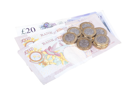 Isolated pile of pound sterling banknotes and new coins in a financial, commerce, business or wealth conceptの写真素材