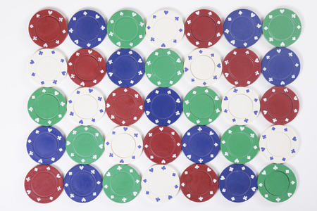 Colorful background of casino chips arranged in an abstract geometric pattern laid out in rows...