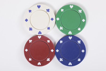 Gambling concept with four different isolated casino chips in red, green, blue and white for different denominations with lateral copy spaceの写真素材