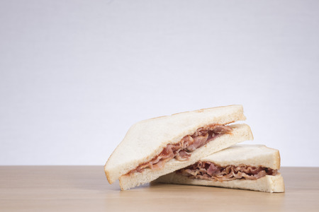 Meat sandwich cut in half on table against white backgroundの写真素材