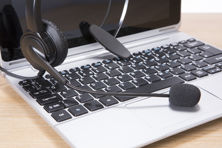Open laptop with headset in a communication, business relations, customer service, telemarketing and helpline conceptの写真素材