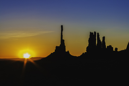 The Totem Pole and Yei Bi Chei rocky spiers with the rising sun in Monument Valley Navajo Tribal Park, Arizona.の写真素材