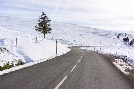 A S-curve cleared road in the Vosges mountains (France) in early winter. This road is a part of the "route des crÃªtes" ("road of the crests"). First snow of the year.の写真素材