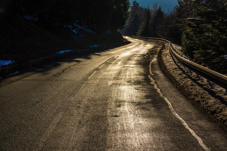 A shiny golden road curve in the Vosges mountains (France) in winter - december 2017の写真素材
