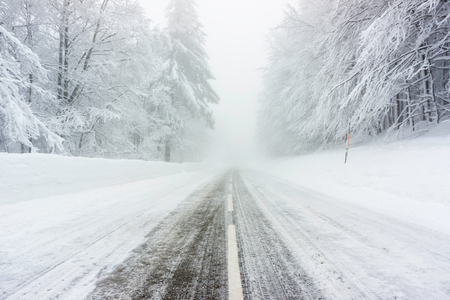 A snowy and icy straight road in the Vosges mountains (France) in winter - december 2017 - horizontalの写真素材